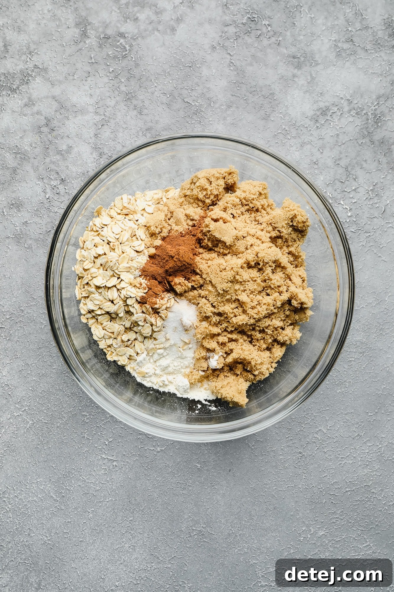 Dry ingredients for the crumble topping (brown sugar, oats, cinnamon, flour) perfectly mixed together in a glass bowl.