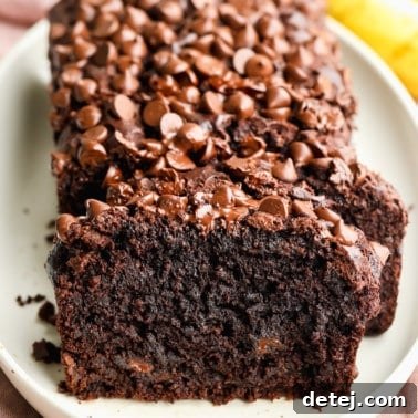 a sliced loaf of vegan chocolate banana bread on a white plate.
