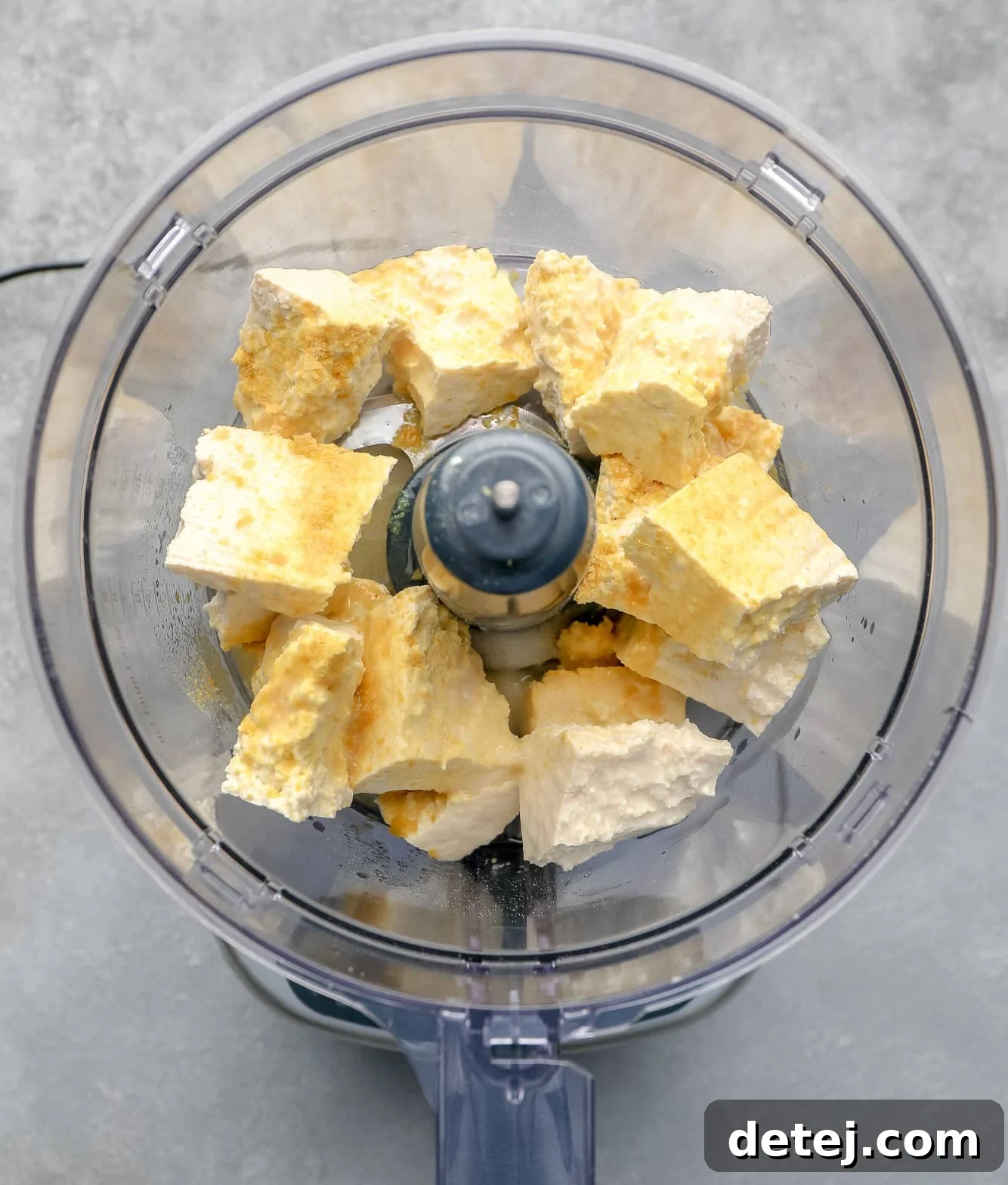 All the five core ingredients for tofu cream cheese placed inside a food processor, ready to blend.