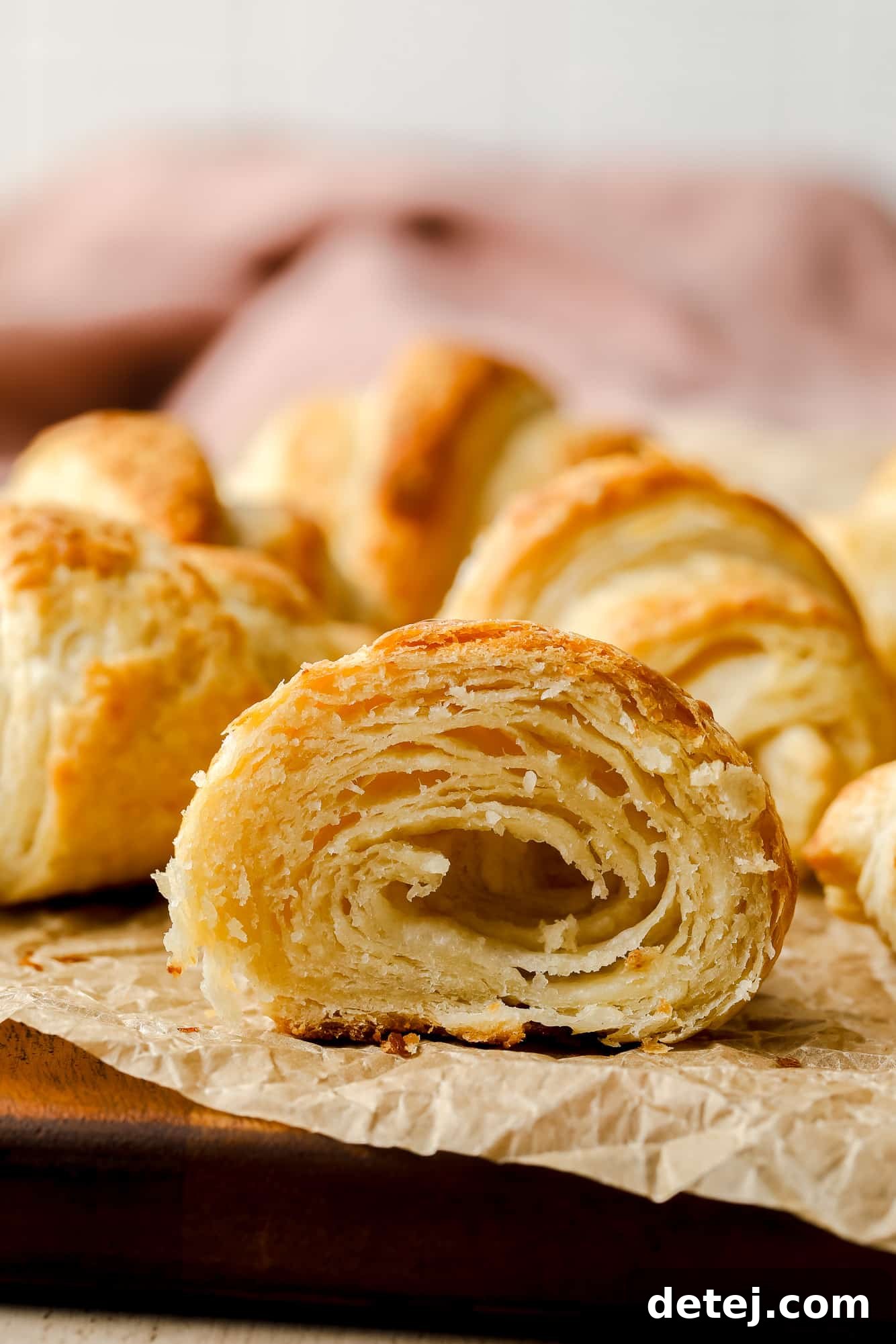Close up on a vegan croissant cut in half, revealing its beautiful, airy internal structure and flaky layers.