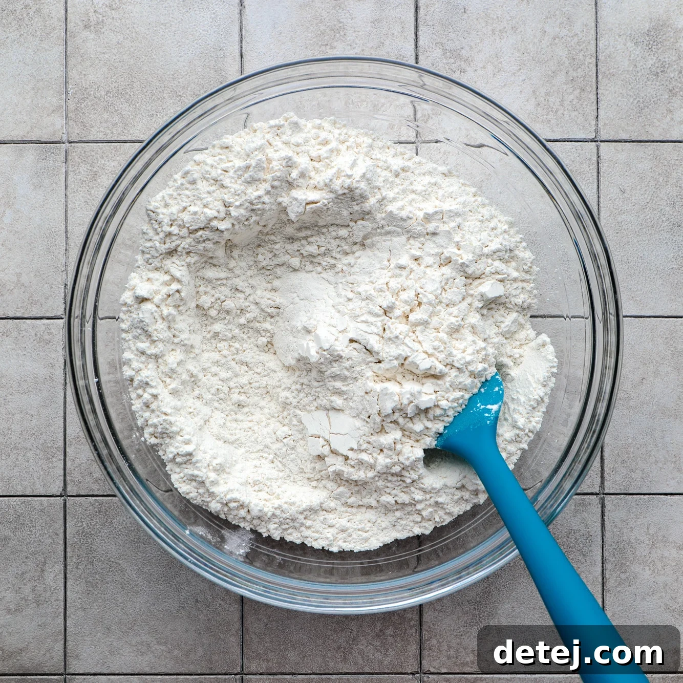 Dry ingredients for vegan focaccia in a clear glass bowl, ready to be mixed.