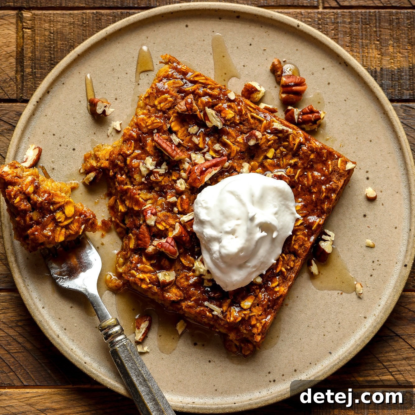 A mouth-watering slice of vegan pumpkin baked oatmeal, adorned with vegan whipped cream, ready to be served.