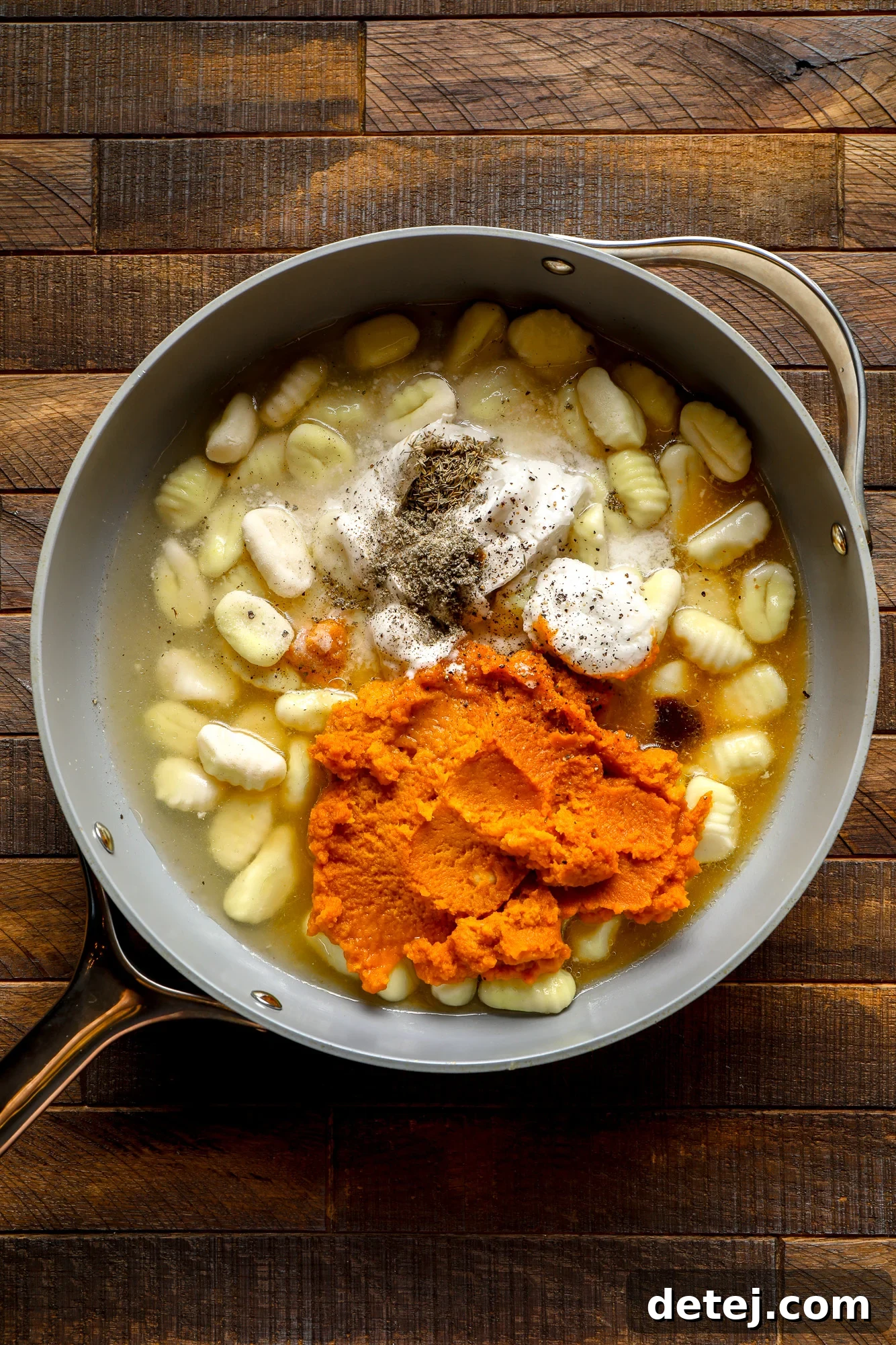 ingredients for pumpkin gnocchi in a grey pot.