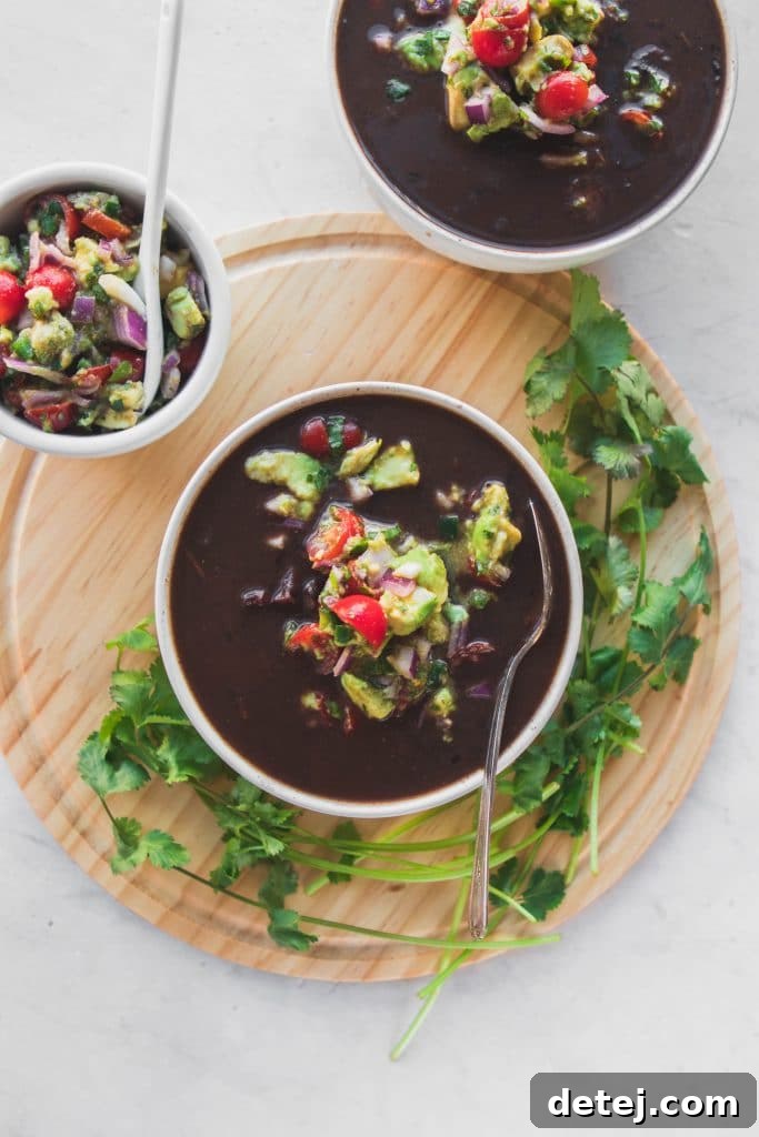 25 Effortless Vegetarian Instant Pot Creations 14 Instant Pot Black Bean Soup in a bowl, topped with fresh avocado and cilantro