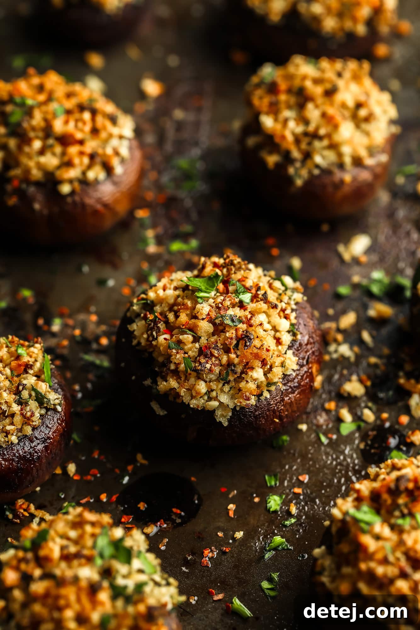 Savory Vegan Mushroom Delights 2 close up on a baked stuffed mushroom with a vegan parmesan and breadcrumb filling.