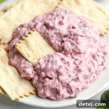 Delicious Cranberry Jalapeno Dip on a plate with crackers.