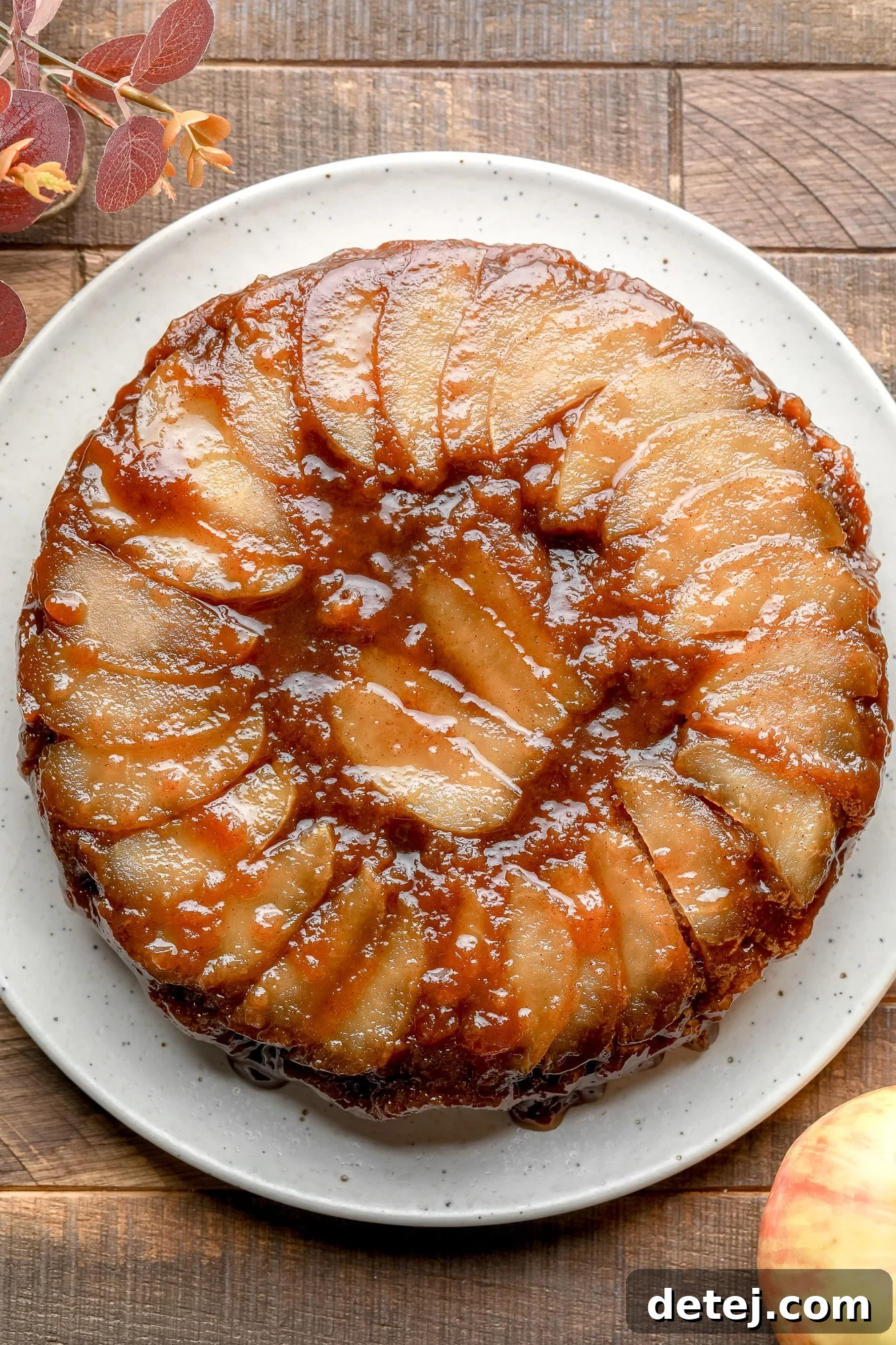 A baked Apple Upside Down Cake on a white plate, showcasing its complete, beautiful form.