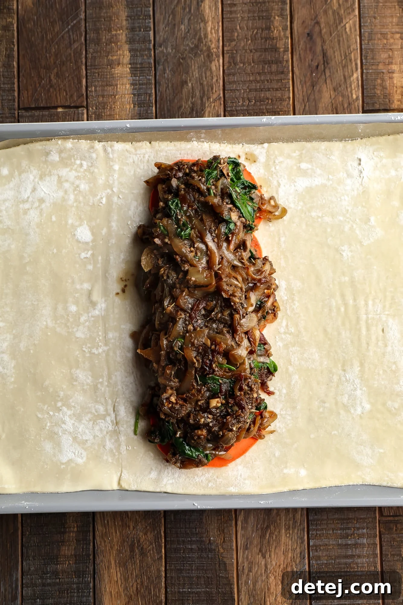 assembling the sweet potato and mushroom filling for mushroom wellington on a sheet of puff pastry.