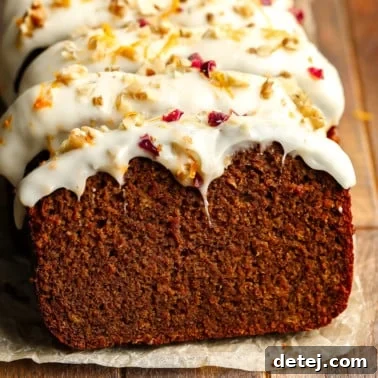 Cozy Gingerbread Bake 13 close up on a sliced Gingerbread Loaf decorated with cream cheese frosting.