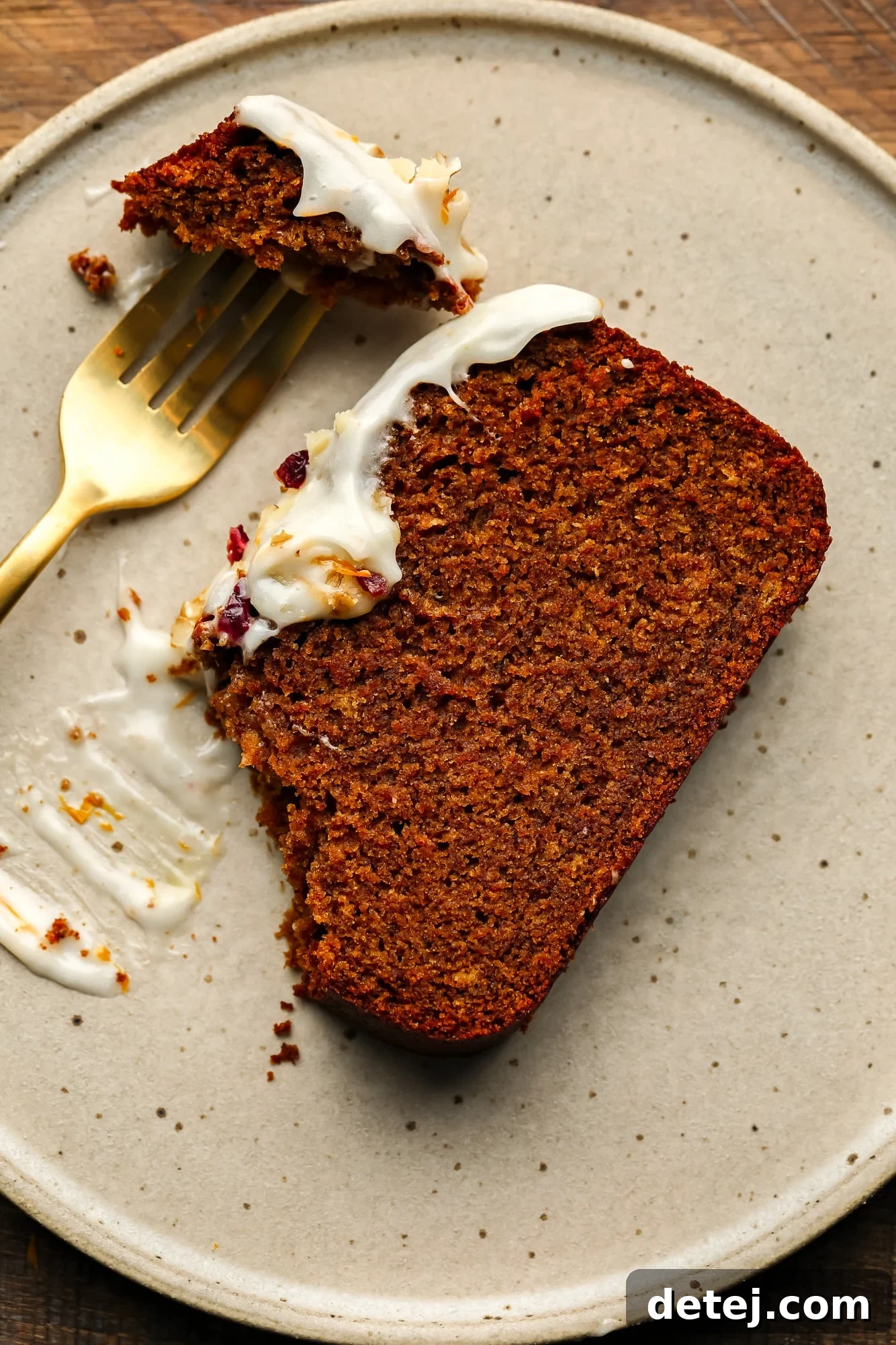 Cozy Gingerbread Bake 3 using a fork to eat a slice of a gingerbread loaf on a beige plate.