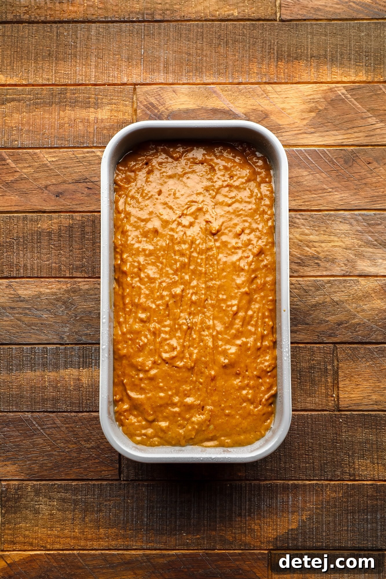 Cozy Gingerbread Bake 8 an unbaked gingerbread loaf in a metal loaf pan.