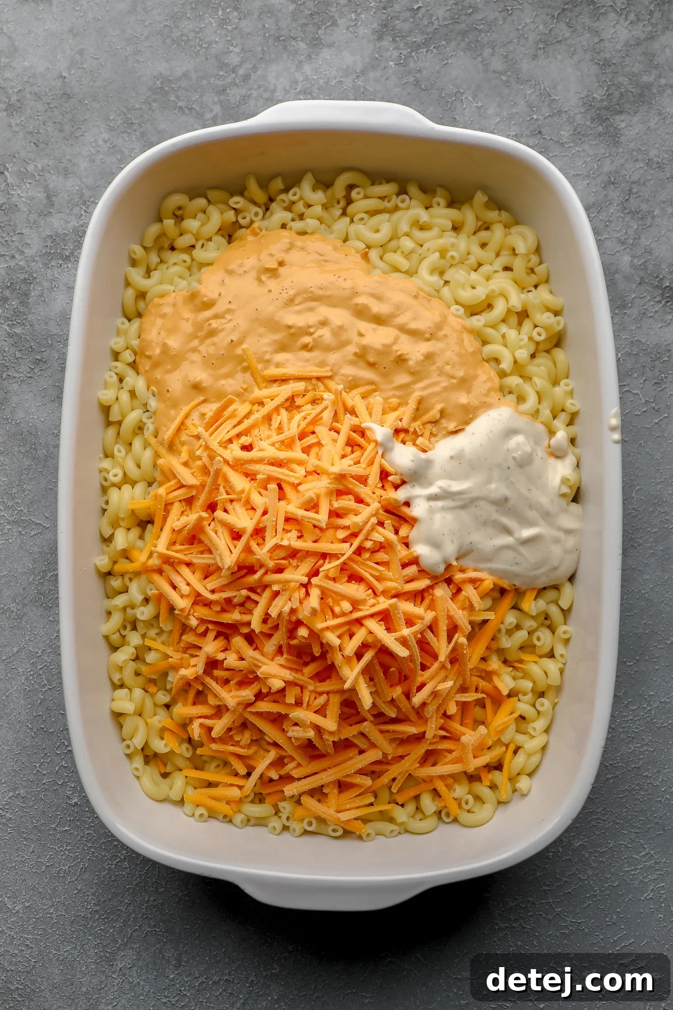 Creamy Vegan Buffalo Mac and Cheeze 5 assembling the ingredients for Vegan Buffalo Mac and Cheese in a large white casserole dish.