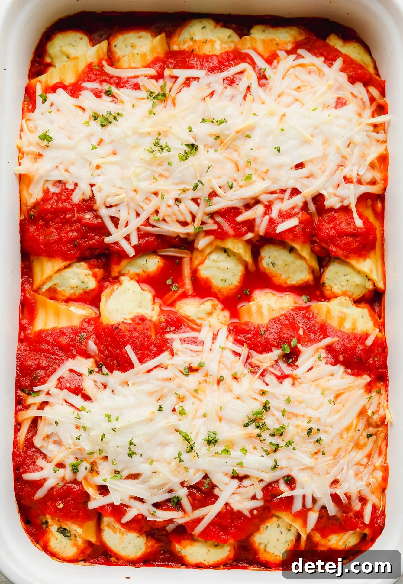 Plant-Based Manicotti 5 baked manicotti topped with marinara sauce and vegan mozzarella in a white baking dish.