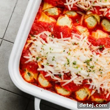 Plant-Based Manicotti 7 close up on vegan manicotti topped with vegan mozzarella in a white baking dish.