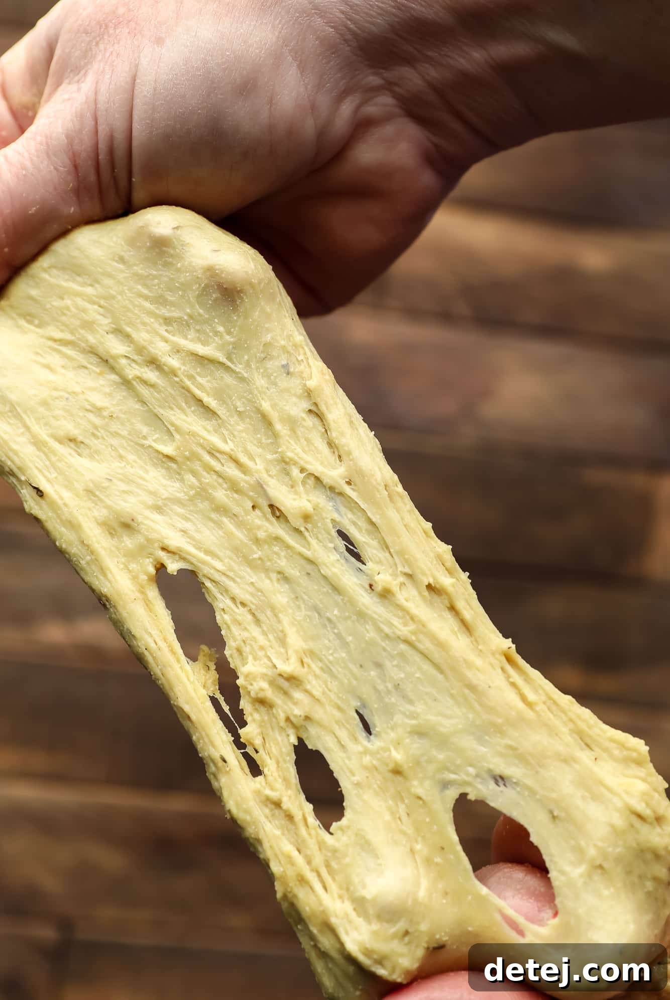 Effortless Seitan 5 two hands stretching raw seitan dough.