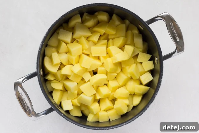 Chopped Yukon Gold potatoes cooking in a large pot of boiling water.