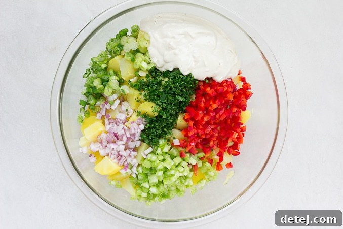 All prepped ingredients for vegan potato salad in a large bowl, before mixing.