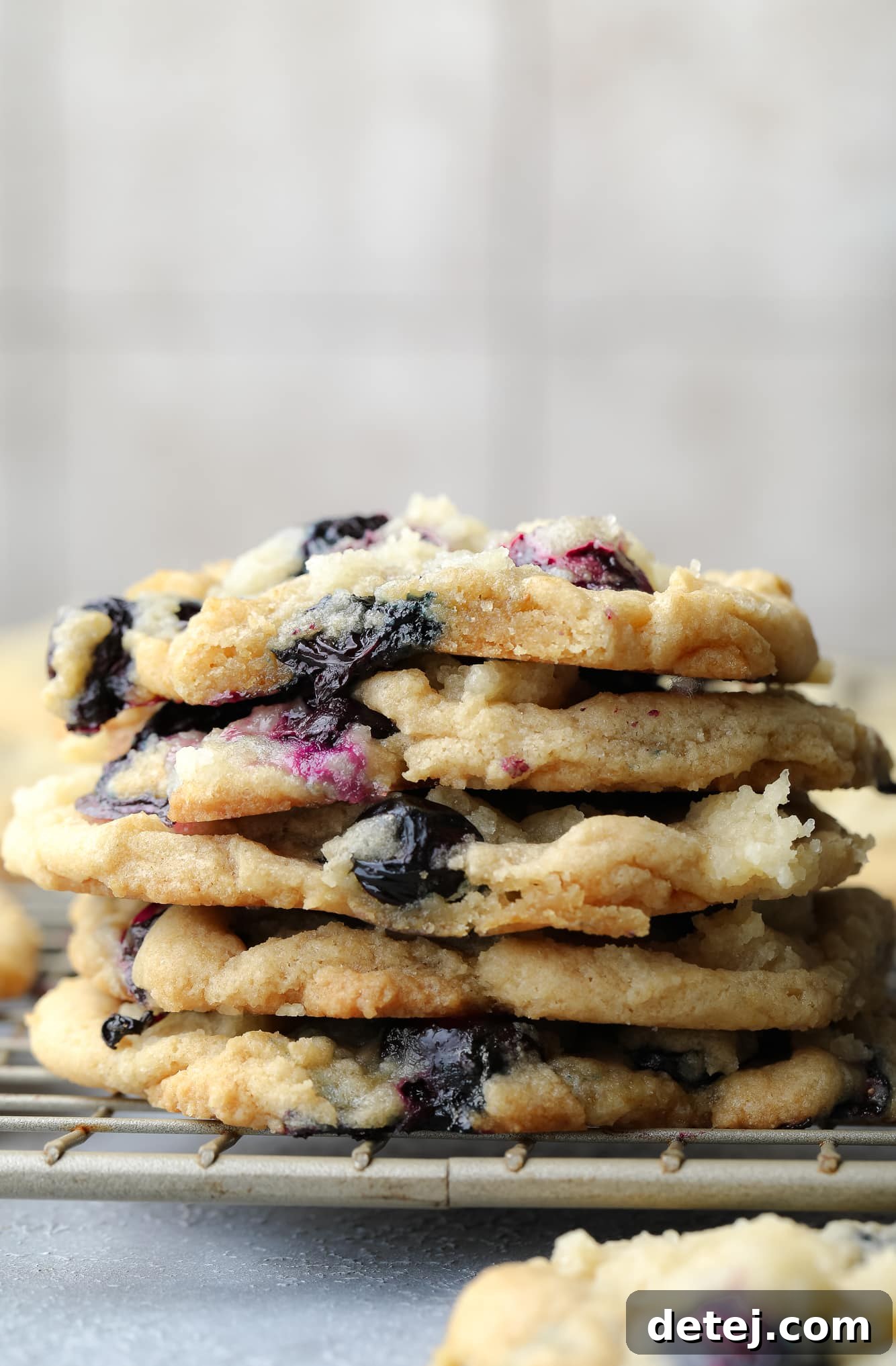 a stack of vegan blueberry cookies on a wire rack.