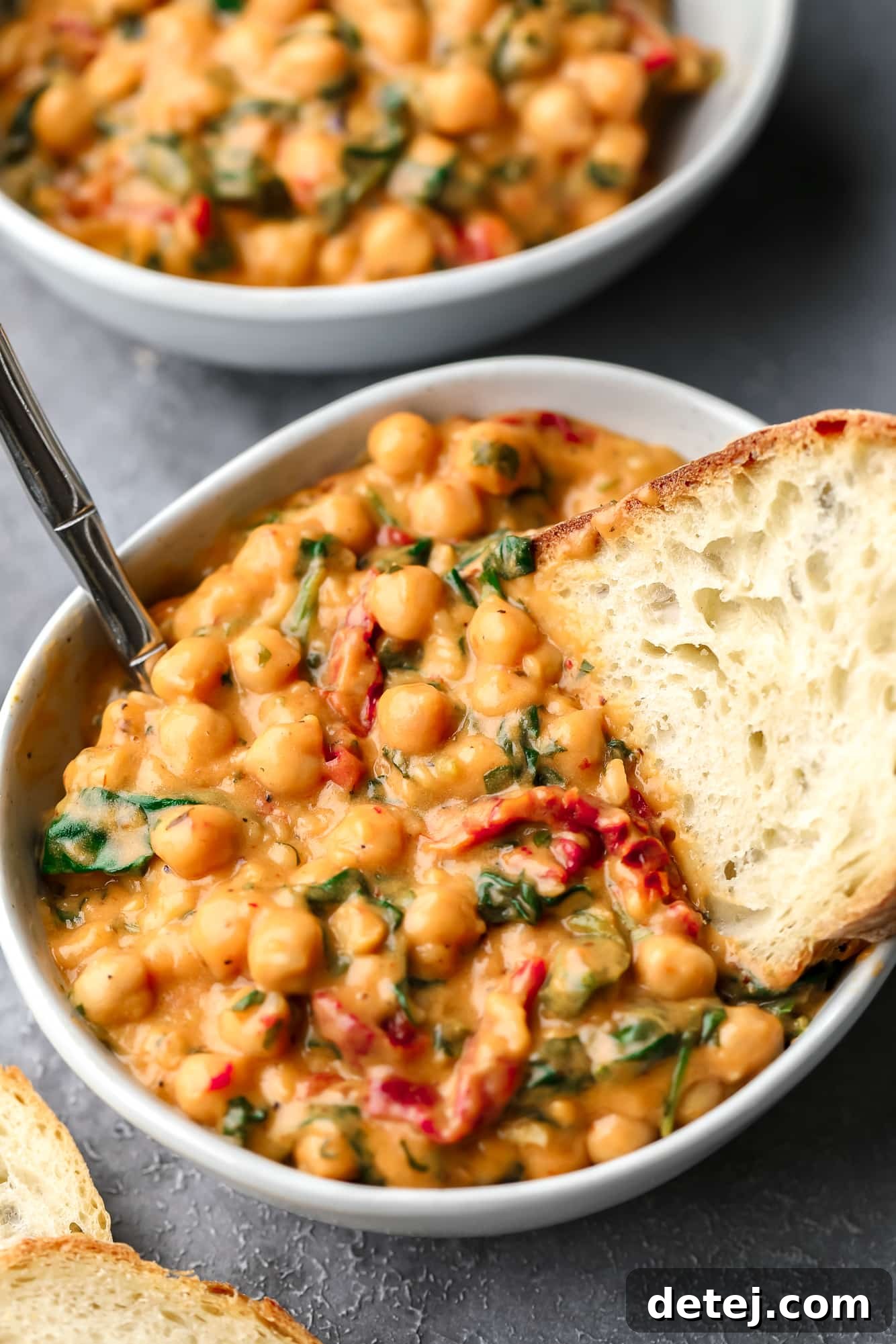 The Chickpea Proposal 3 a piece of bread dunked in a bowl of Marry Me Chickpeas.