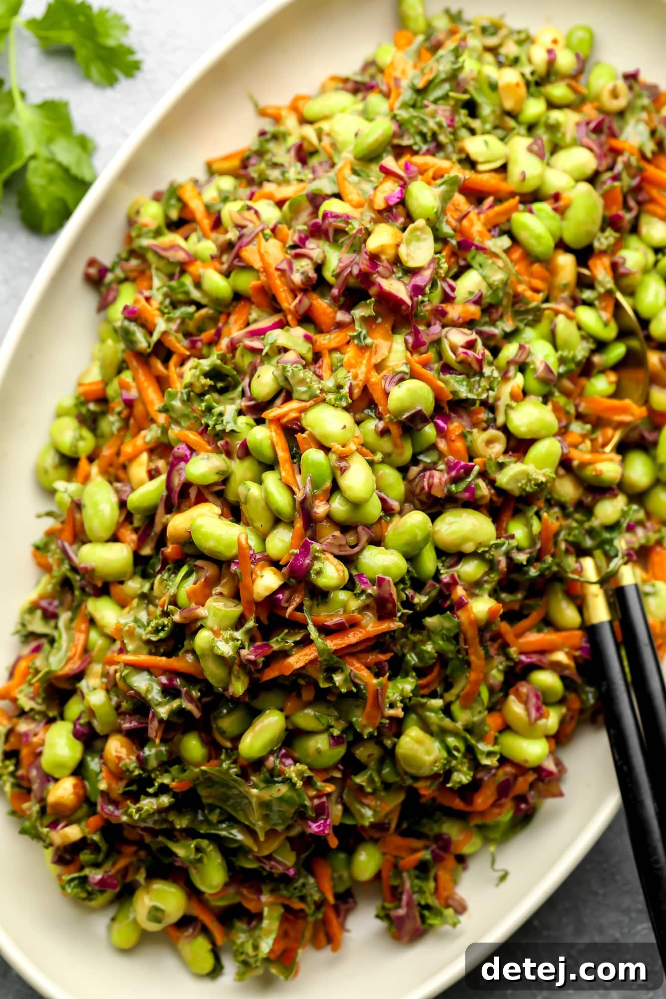The final Edamame Salad with Peanut Sauce generously spread on a white serving platter, showcasing its rich colors and appetizing texture, ready to be portioned and enjoyed.