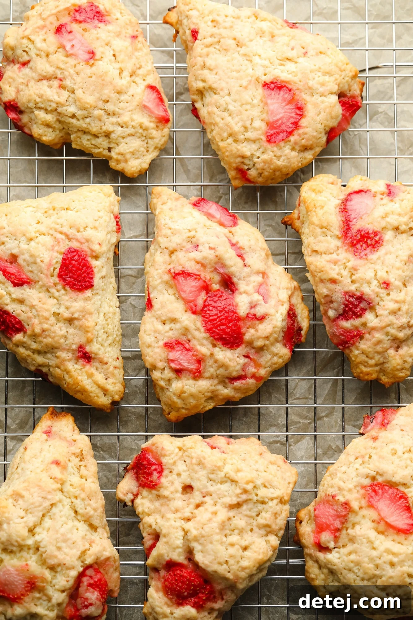 Close-up of baked vegan strawberry scones on a wire rack, showcasing their fluffy texture.