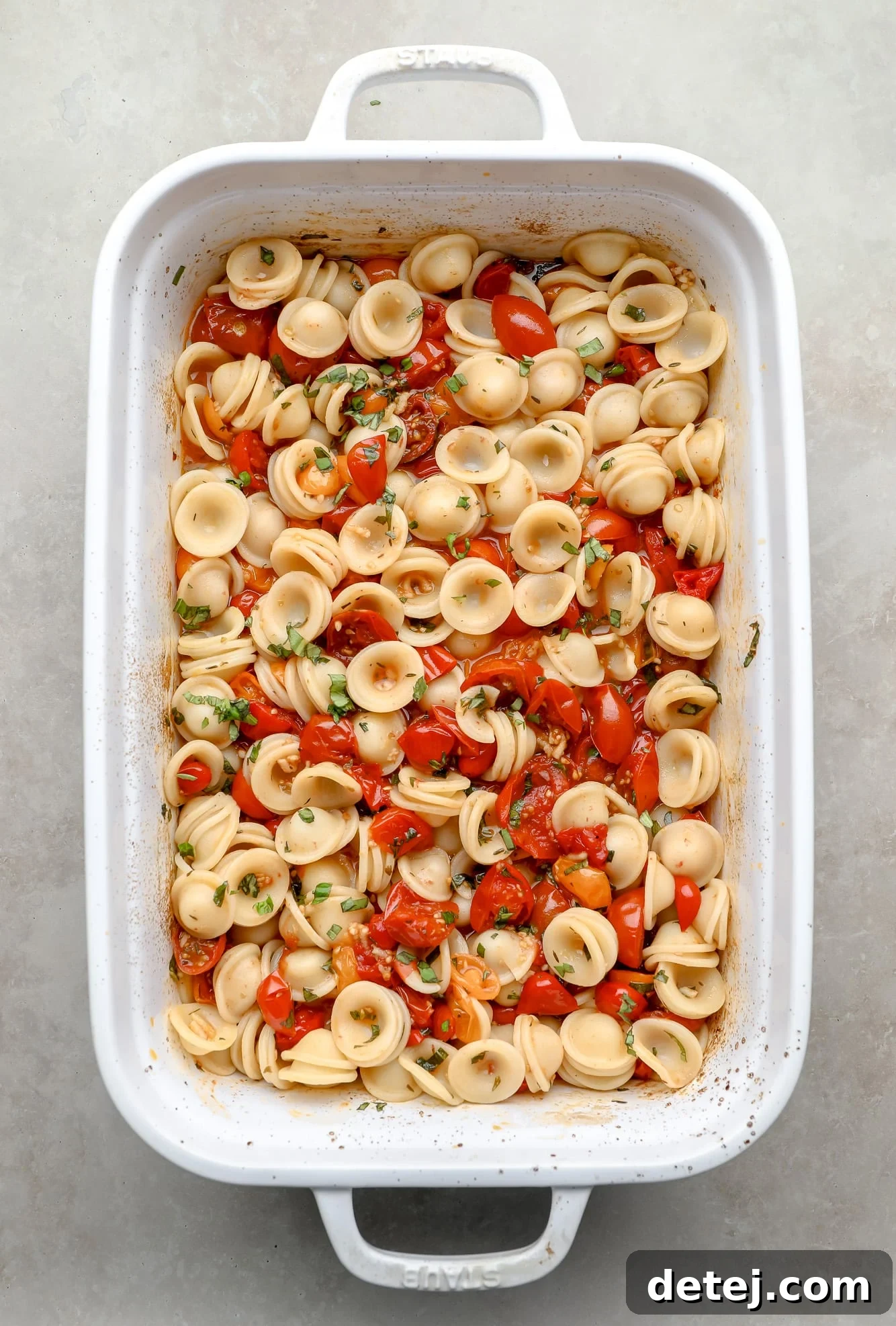 Roasted Tomato Pasta fully tossed with fresh basil and herbs, beautifully mixed in a white baking dish and ready for serving.