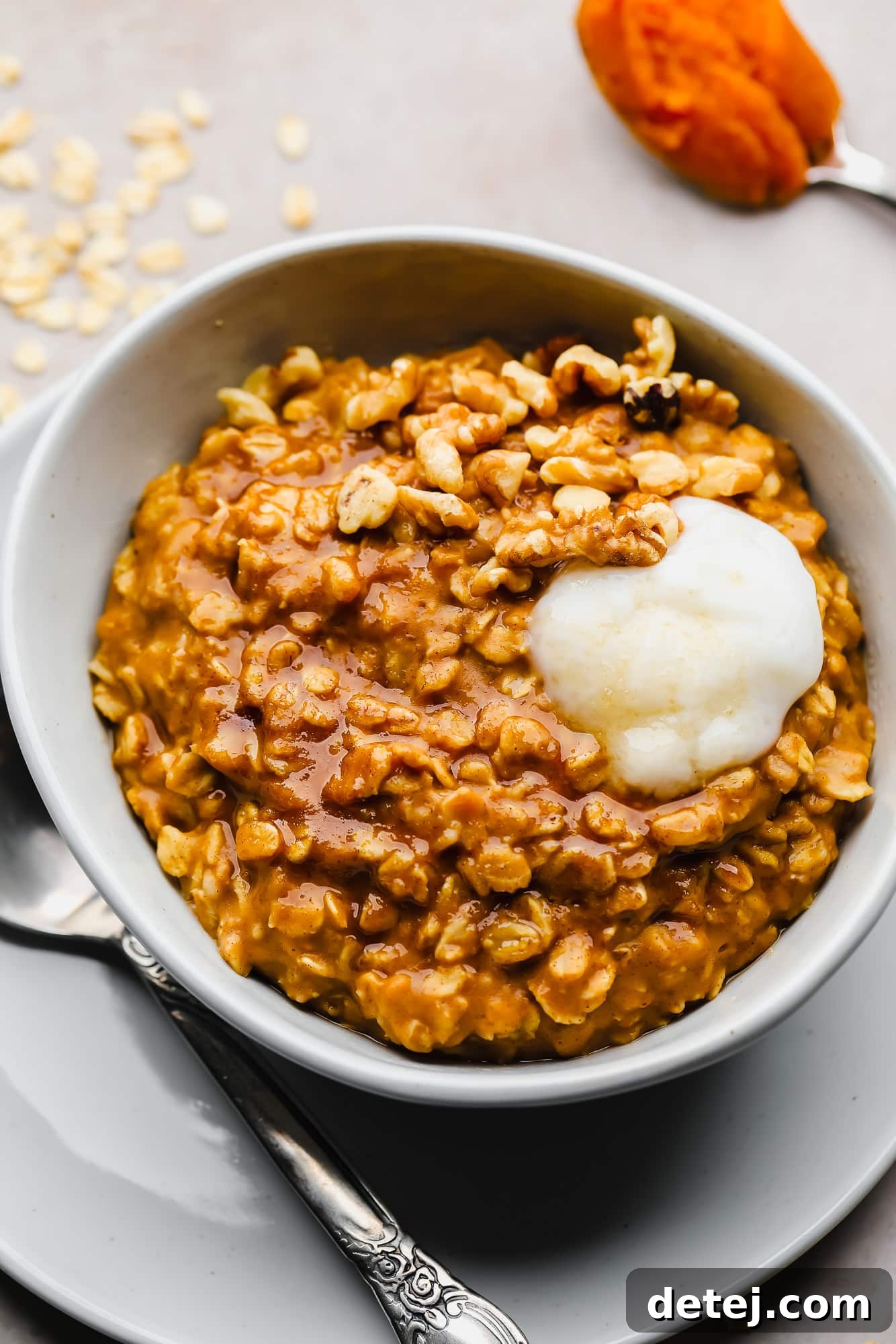 A bowl of warm and cozy Vegan Pumpkin Oatmeal, topped with a dollop of vegan yogurt, ready to be enjoyed.