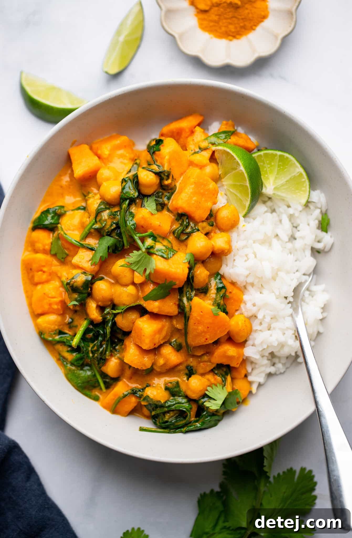 Sweet Potato Curry with Chickpeas served with white rice in a white bowl.