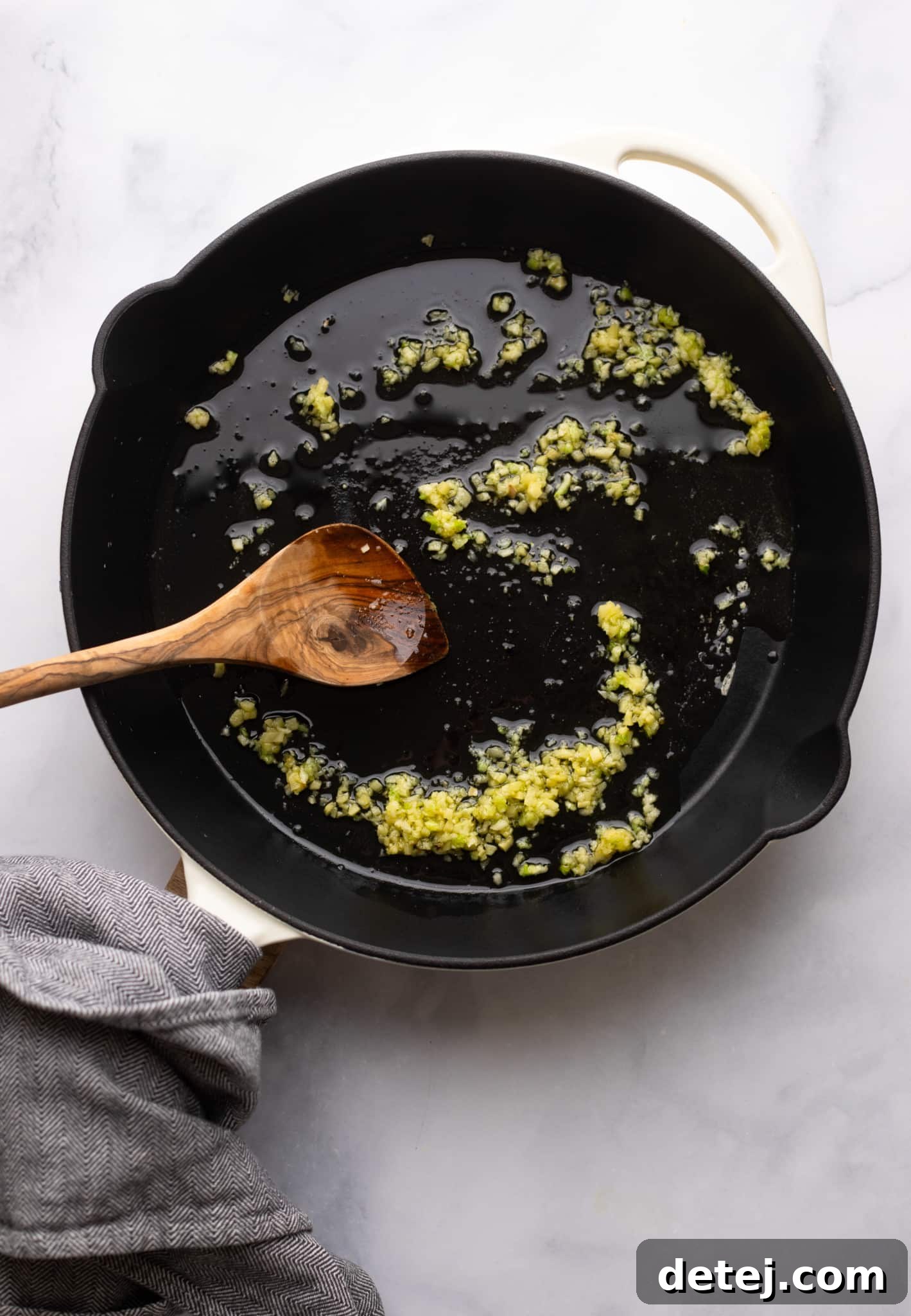 cooking garlic in a black skillet.