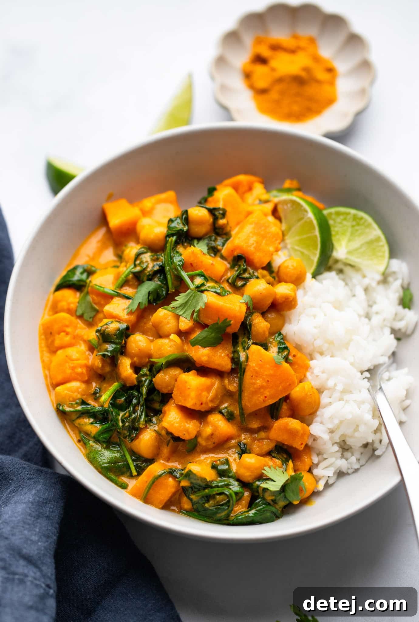 Sweet Potato Curry with Chickpeas served with white rice in a white bowl.
