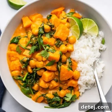 Sweet Potato Curry with Chickpeas served with white rice in a white bowl.