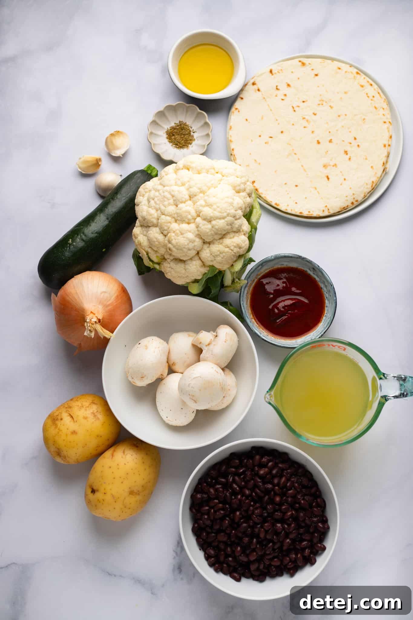 A vibrant flat lay image showcasing all the fresh ingredients needed for making Roasted Veggie Enchiladas with Black Bean Sauce, including chopped vegetables, canned black beans, and tortillas.