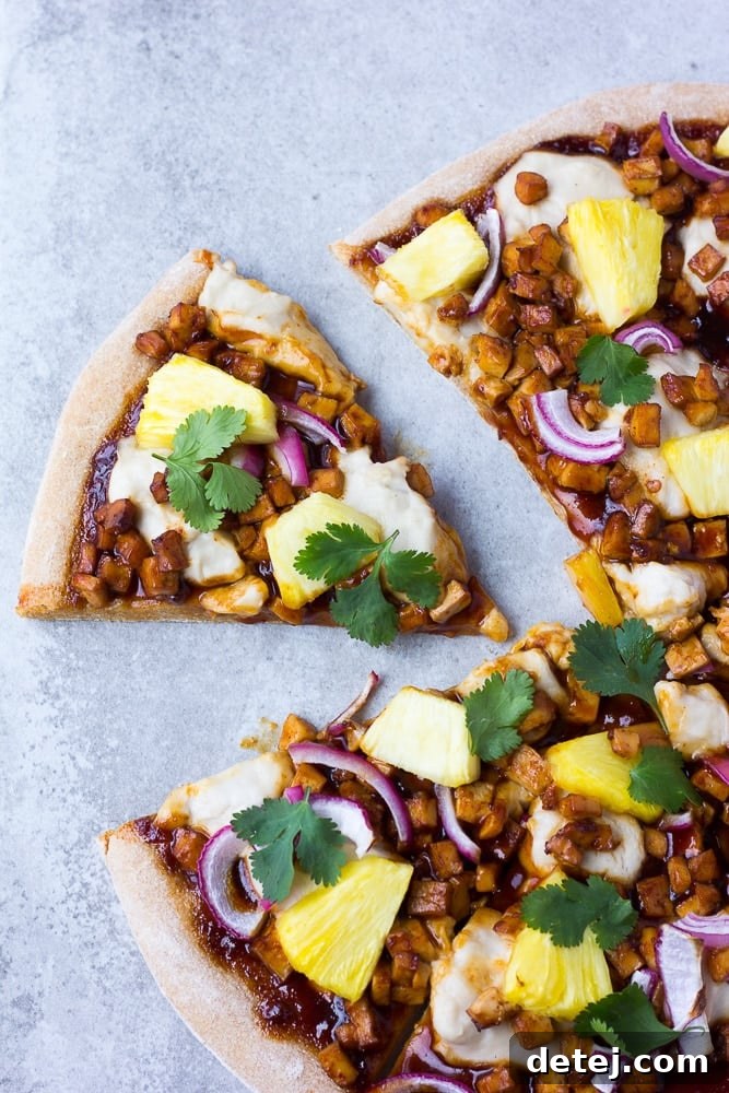 Delicious Hawaiian BBQ Vegan Pizza with barbecue tofu, pineapple, and red onion, garnished with fresh cilantro.