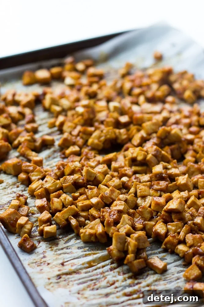Cooked barbecue tofu pieces, glistening with sauce, after their second bake, looking chewy and flavorful.