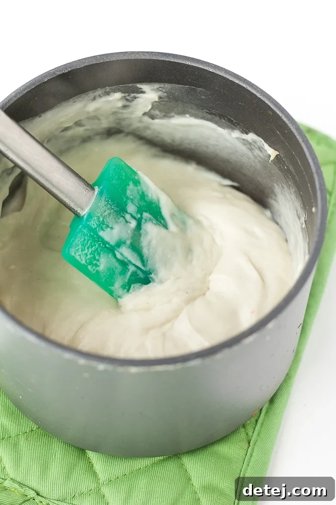 Close-up of homemade vegan mozzarella cheese, showcasing its stretchy and creamy texture, perfect for pizza.