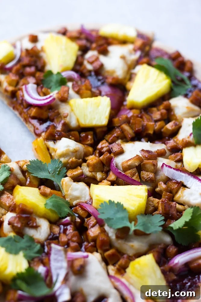 Finished Hawaiian BBQ Vegan Pizza, freshly baked with bubbling vegan cheese, golden crust, and colorful toppings.