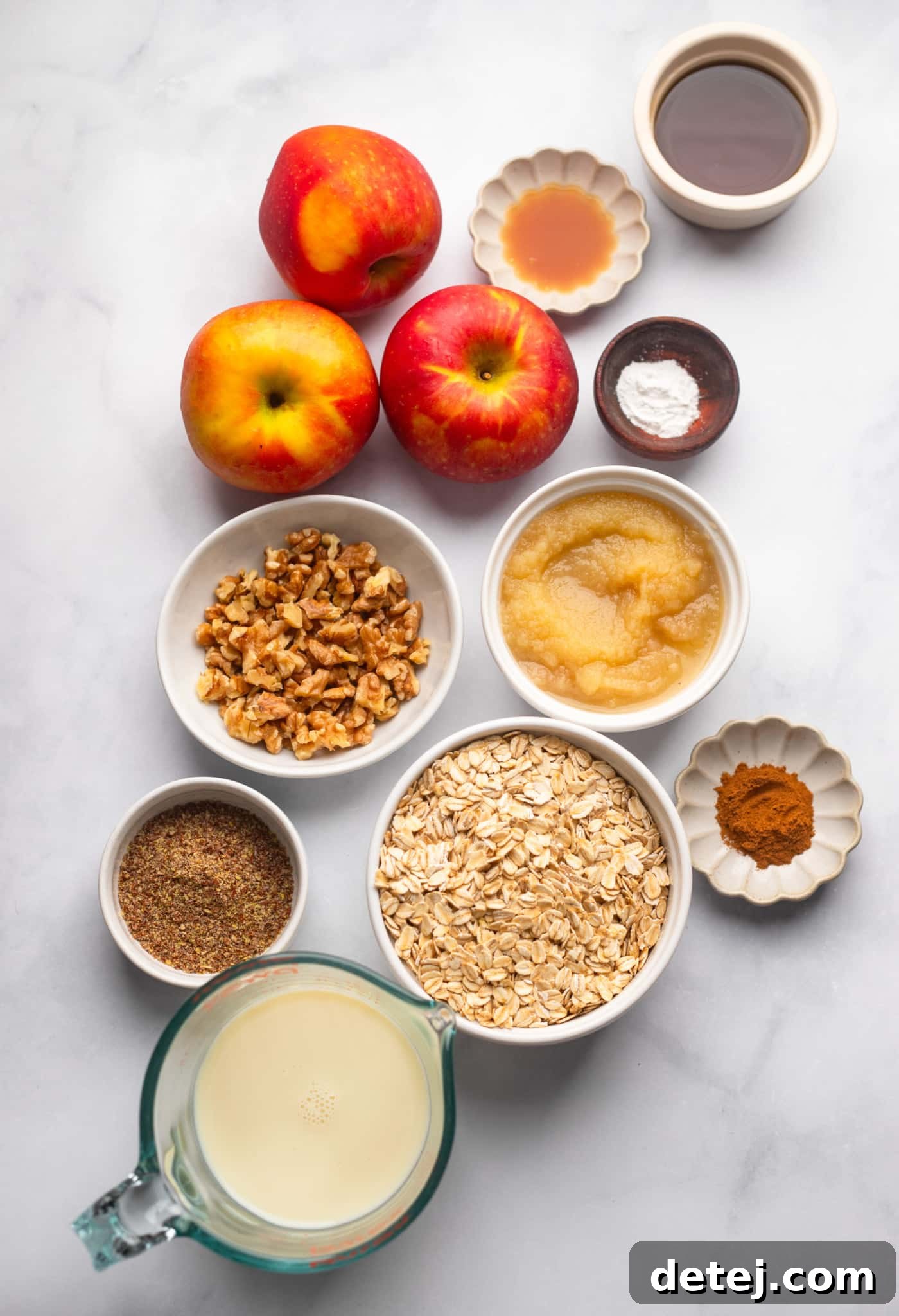 Warm Apple Oat Bake 3 Various ingredients for apple baked oatmeal, including oats, apples, and spices, presented in individual white bowls.