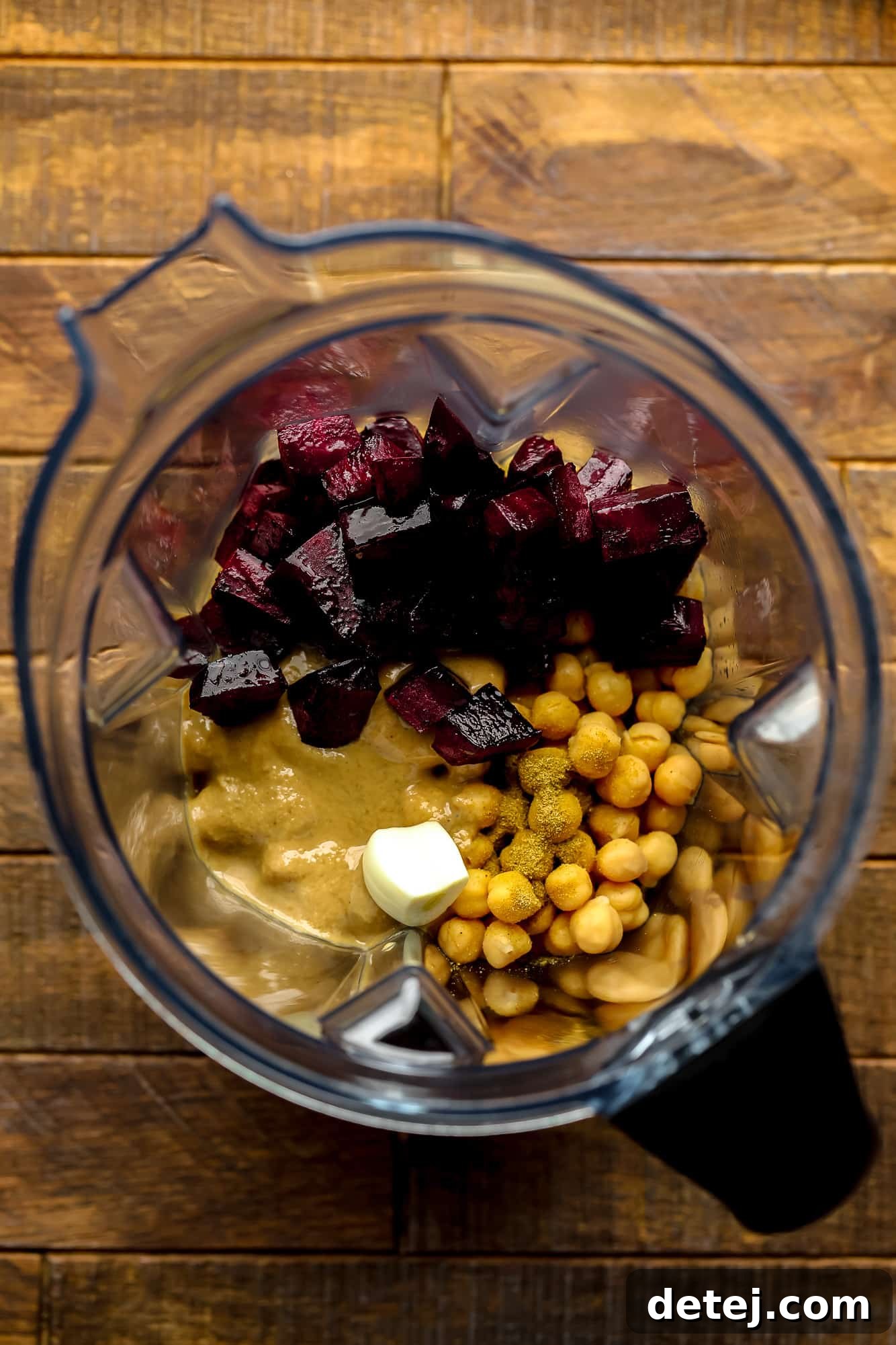Ruby Red Hummus 4 All the essential ingredients for beet hummus, including roasted beets, chickpeas, and tahini, ready to be blended in a high-powered machine.