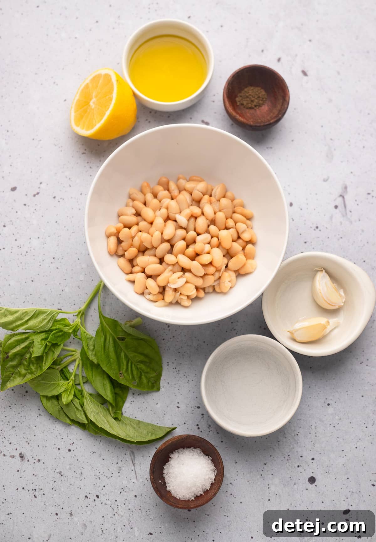 ingredients for white bean dip in individual white bowls.