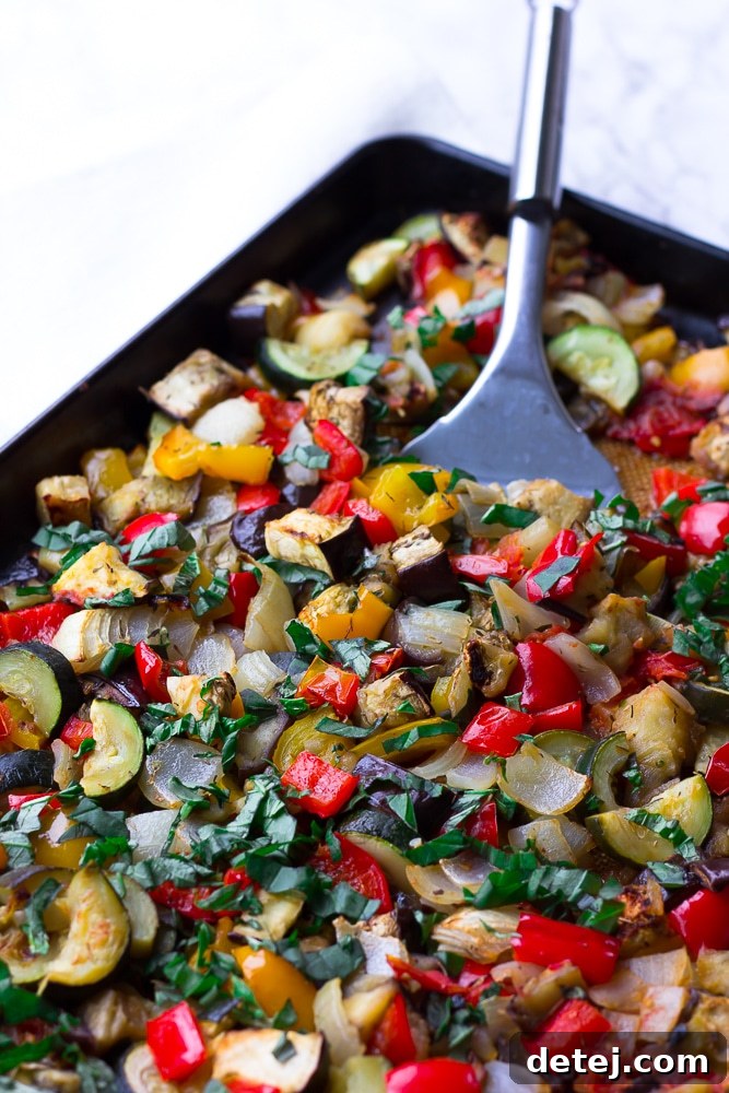 Roasted Ratatouille vegetables spread evenly on a baking pan, beautifully browned and tender, fresh from the oven.