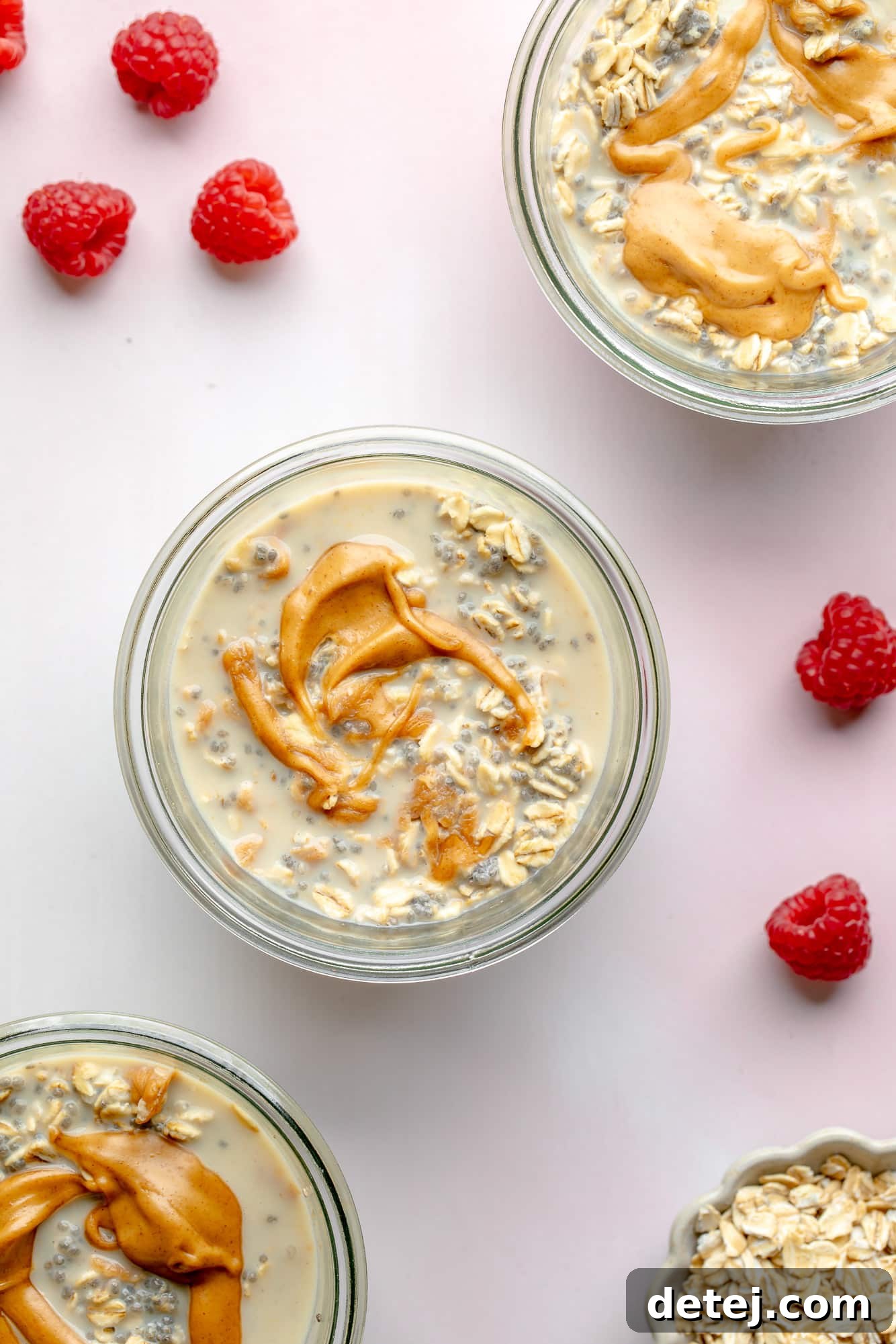 Overhead view of multiple jars of peanut butter overnight oats, artfully arranged to highlight their readiness for meal prep and delicious appeal.