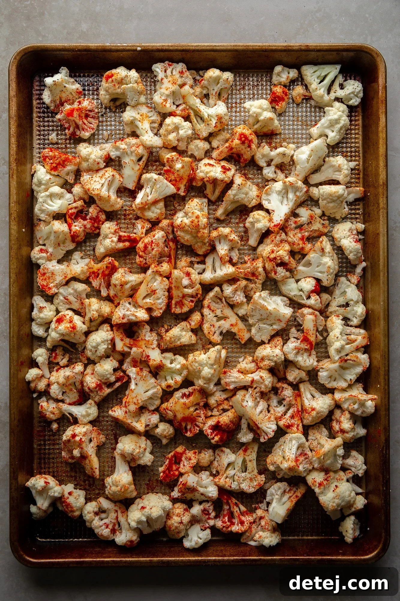 seasoned cauliflower florets on a baking sheet.
