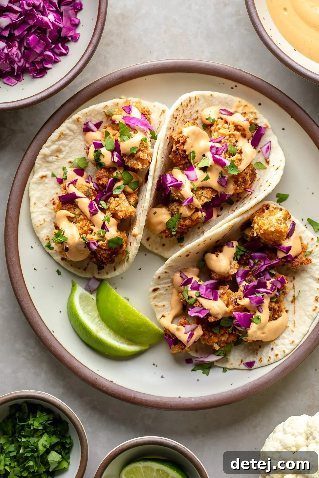 Three crispy cauliflower tacos arranged beautifully on a plate, ready to be enjoyed.