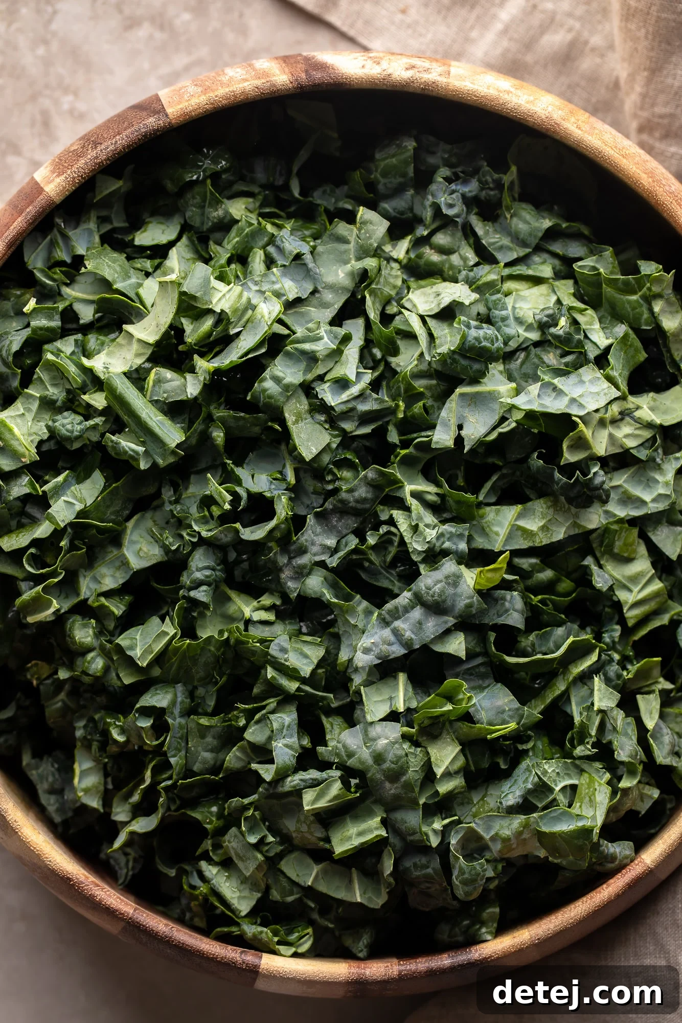Freshly chopped kale in a large salad bowl, ready for dressing and toppings.