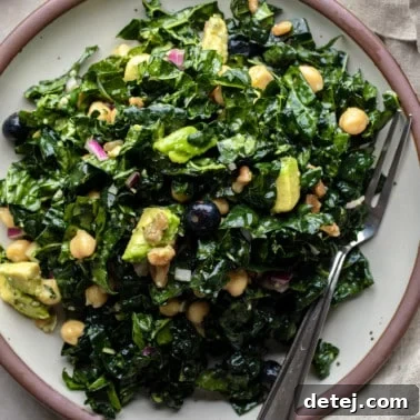 A close-up shot of the finished kale salad on a plate, highlighting its appetizing texture and colorful components.