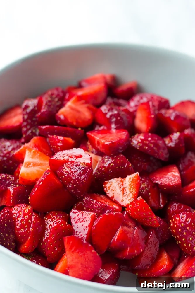 Freshly cut strawberries in a bowl, macerating with sugar