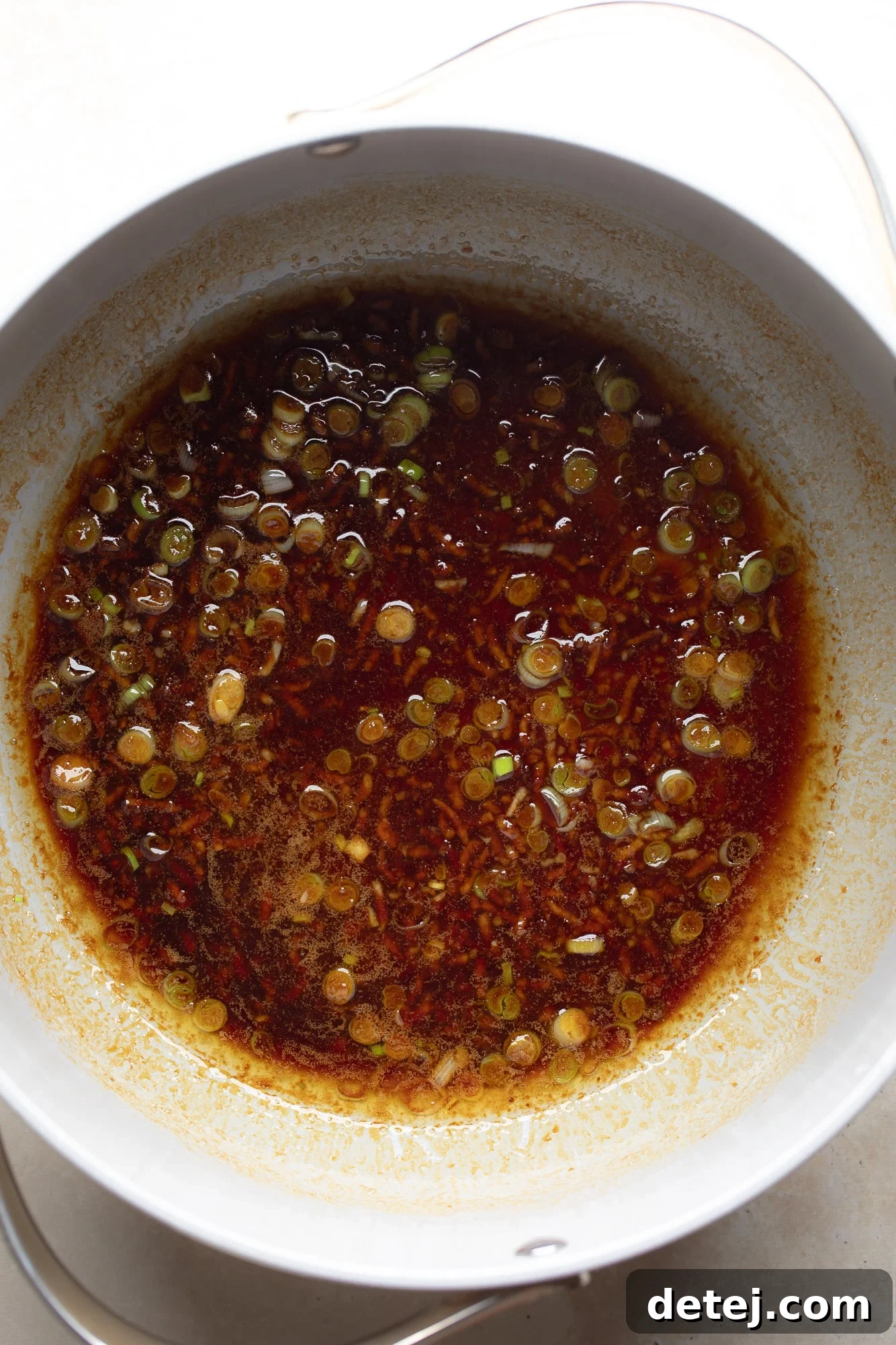 The savory garlic sauce simmering gently in a grey skillet, ready to be tossed with noodles for a quick and flavorful meal.