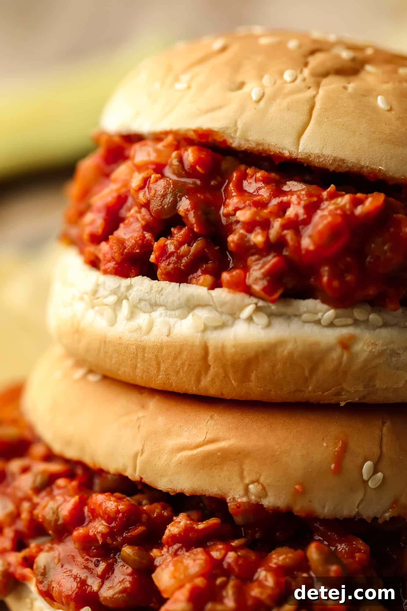 close up on two vegan sloppy joes served in hamburger buns.