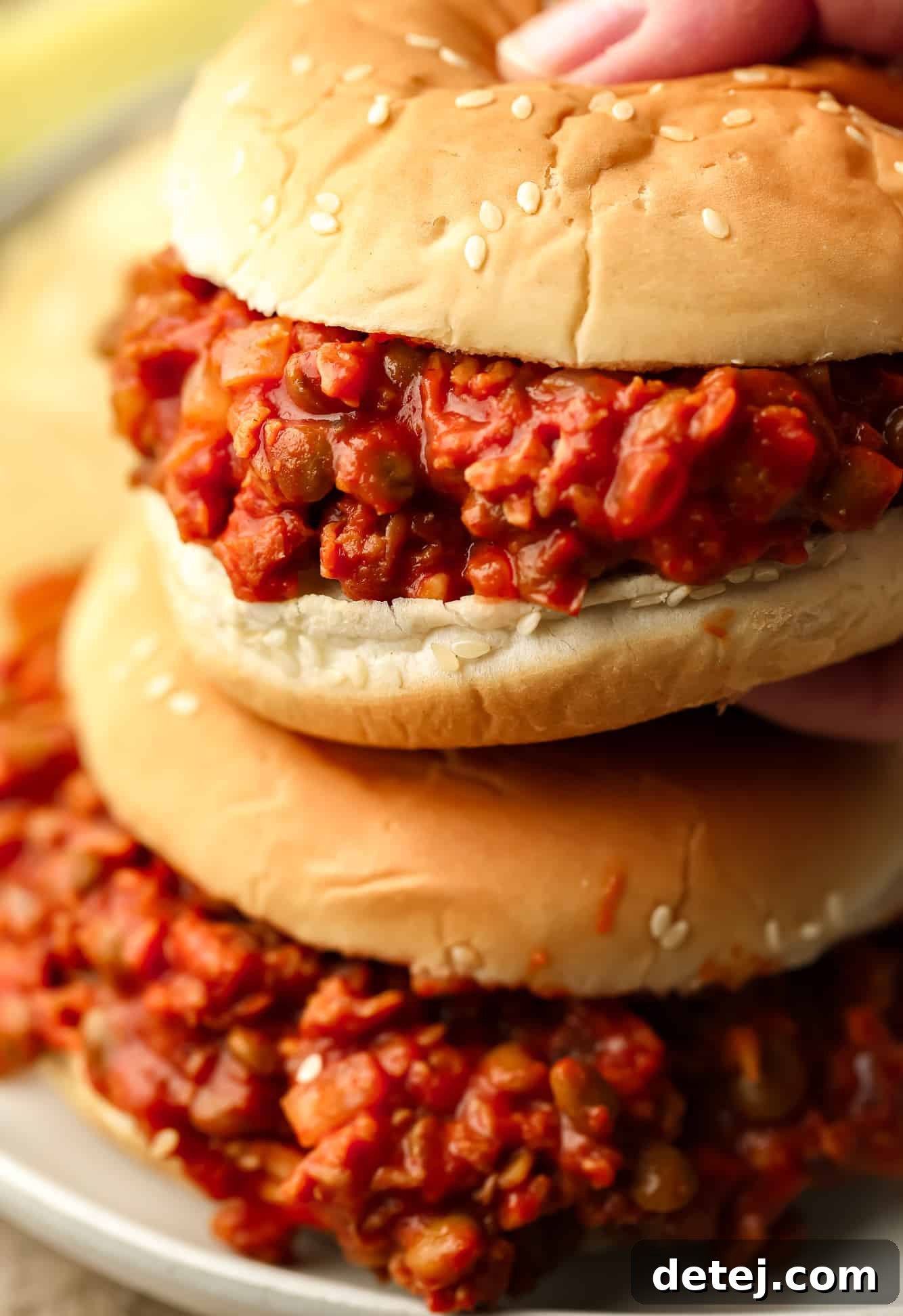 a womans hand grabbing a vegan sloppy joe.