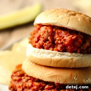 close up on two vegan sloppy joes served in hamburger buns.
